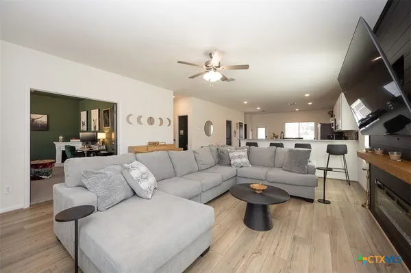 a living room with furniture and a wooden floor