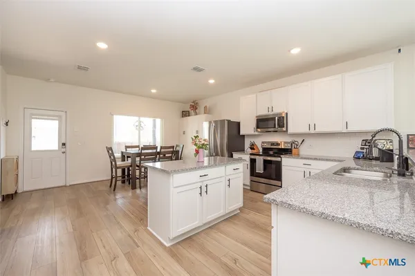 a kitchen with white cabinets and stainless steel appliances