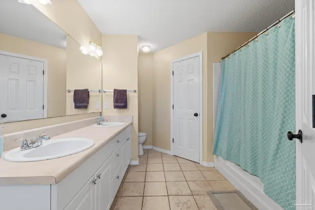 a bathroom with a granite countertop sink a mirror and a shower
