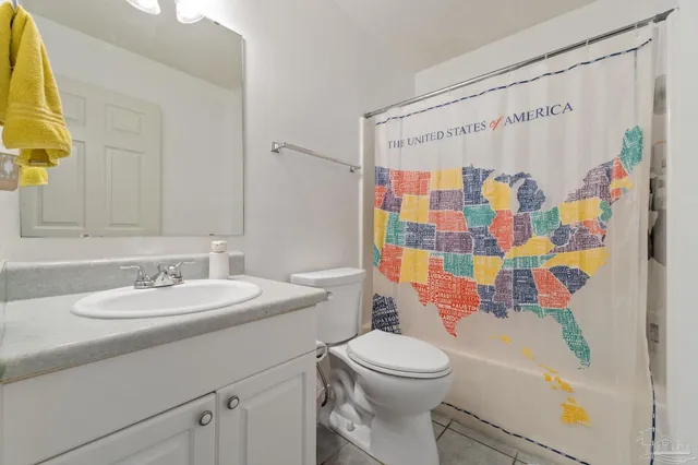 a bathroom with a sink a toilet and a shower curtain
