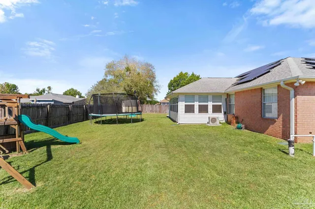 a view of a house with backyard and sitting area