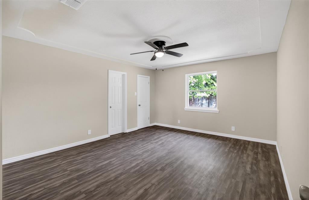 7528 Meadowlark Lane North Watauga, TX 76148 - Photo 19 of 31 an empty room with wooden floor ceiling fan and windows