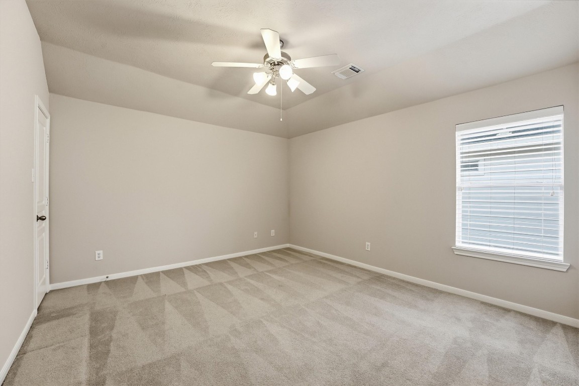 17415 Memorial Mills Drive Spring, TX 77379 - Photo 30 of 37 an empty room with windows and chandelier fan