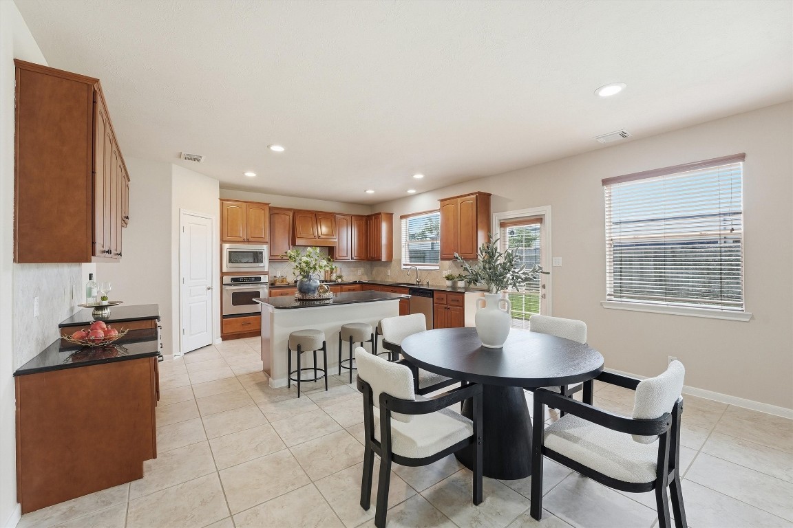 17415 Memorial Mills Drive Spring, TX 77379 - Photo 6 of 37 a kitchen with a dining table chairs and refrigerator