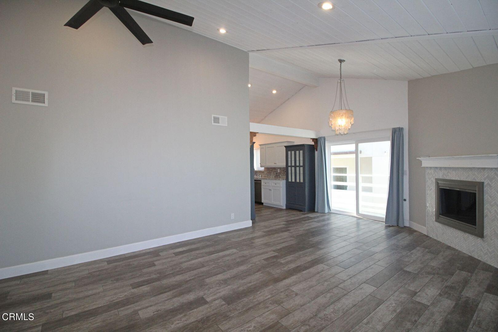 4185 Sunset Lane Oxnard, CA 93035 - Photo 32 of 32 an empty room with wooden floor fireplace and windows