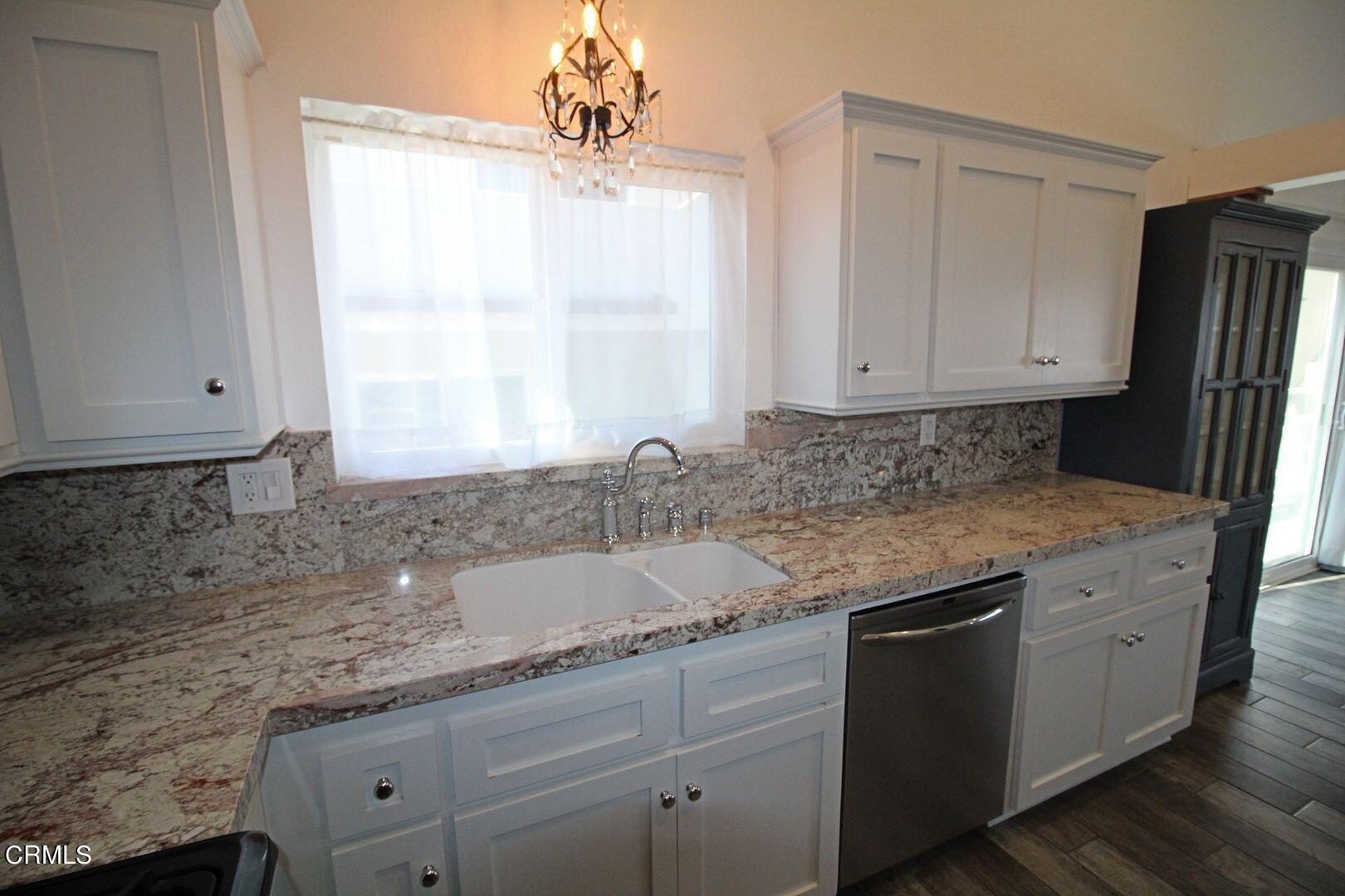 4185 Sunset Lane Oxnard, CA 93035 - Photo 8 of 32 a kitchen with granite countertop a sink window and cabinets