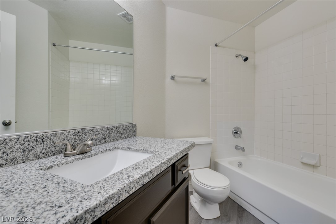 1738 Toltec Circle Henderson, NV 89014 - Photo 38 of 46 A well-appointed bathroom with granite counters and a clean, tiled shower-tub combination.