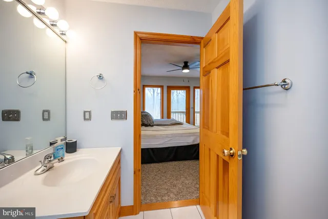 a en suite bathroom with a granite countertop sink and a mirror