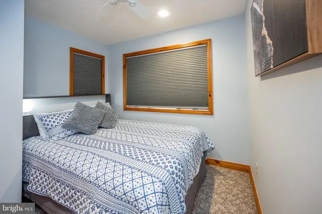 a bedroom with a bed and a lamp on dresser