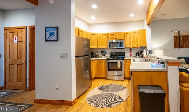 a kitchen with stainless steel appliances granite countertop a refrigerator a stove and a sink