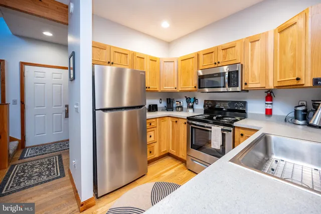 a kitchen with stainless steel appliances granite countertop a refrigerator stove and sink