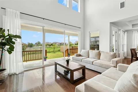 a living room with furniture and a large window with garden view