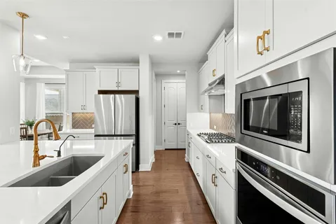 a kitchen with white cabinets and stainless steel appliances