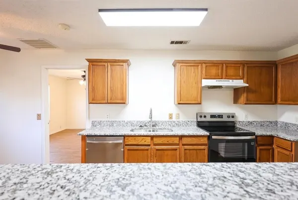 a kitchen with stainless steel appliances granite countertop a sink stove and cabinets