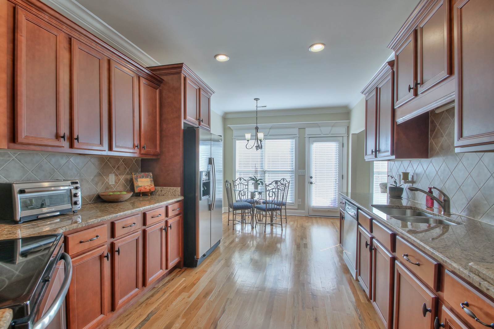 3028 Sakari Circle Spring Hill, TN 37174 - Photo 14 of 46 a kitchen with stainless steel appliances granite countertop a refrigerator a sink dishwasher a stove and white countertops with wooden floor