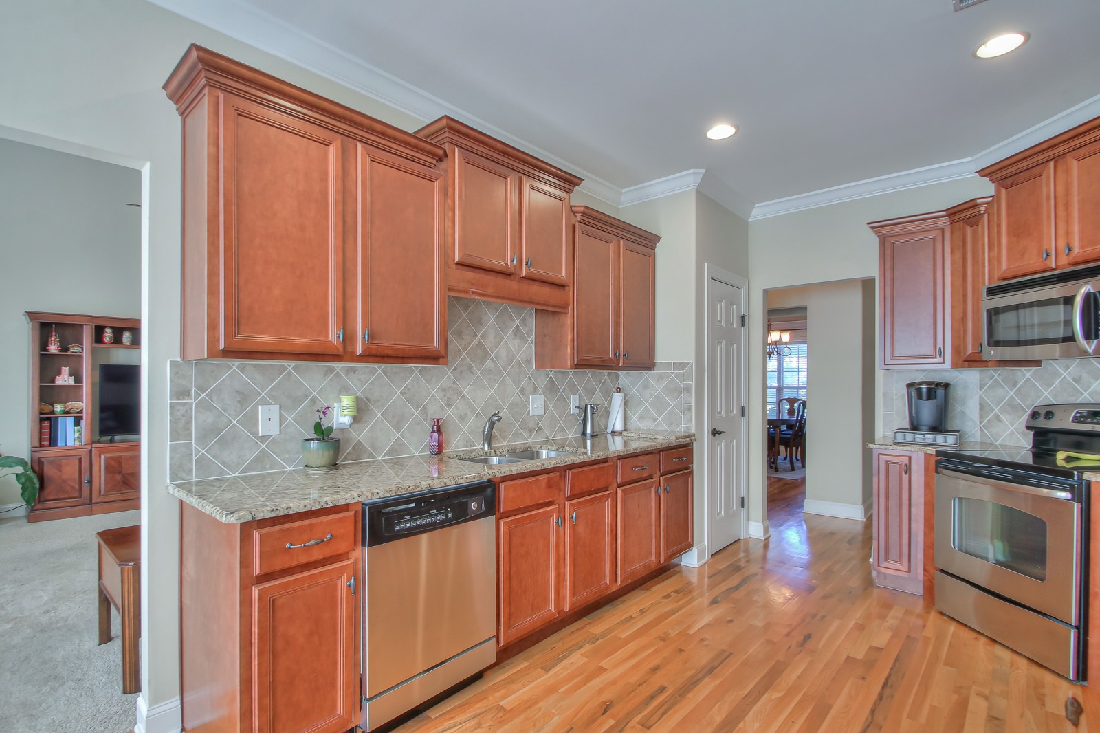 3028 Sakari Circle Spring Hill, TN 37174 - Photo 16 of 46 a kitchen with stainless steel appliances granite countertop wooden cabinets a sink and dishwasher a stove with wooden floor