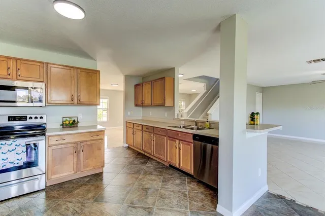 a kitchen with stainless steel appliances granite countertop a refrigerator and a stove top oven