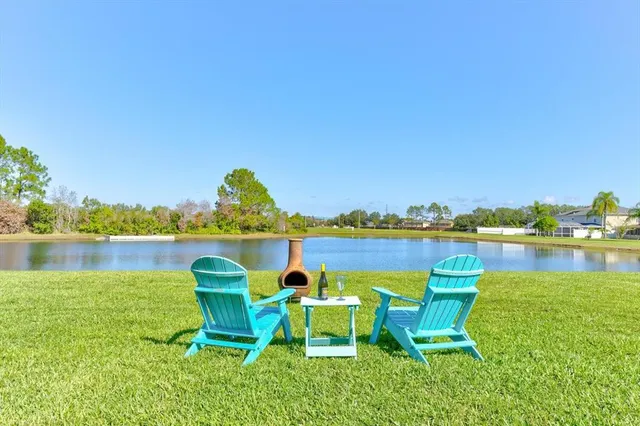 a view of a lake with table and chairs