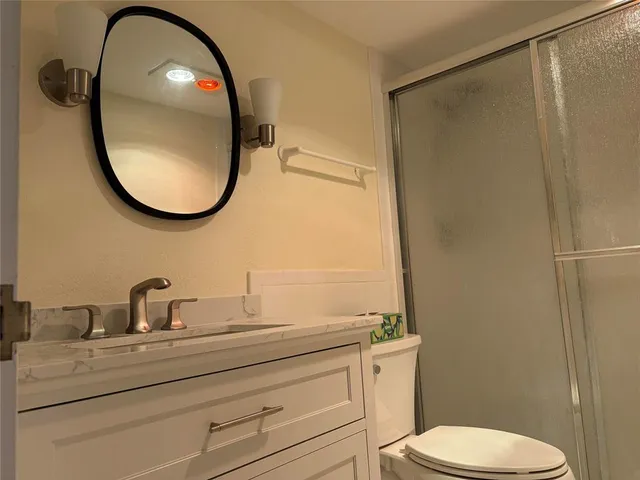 a bathroom with a toilet a sink and a mirror