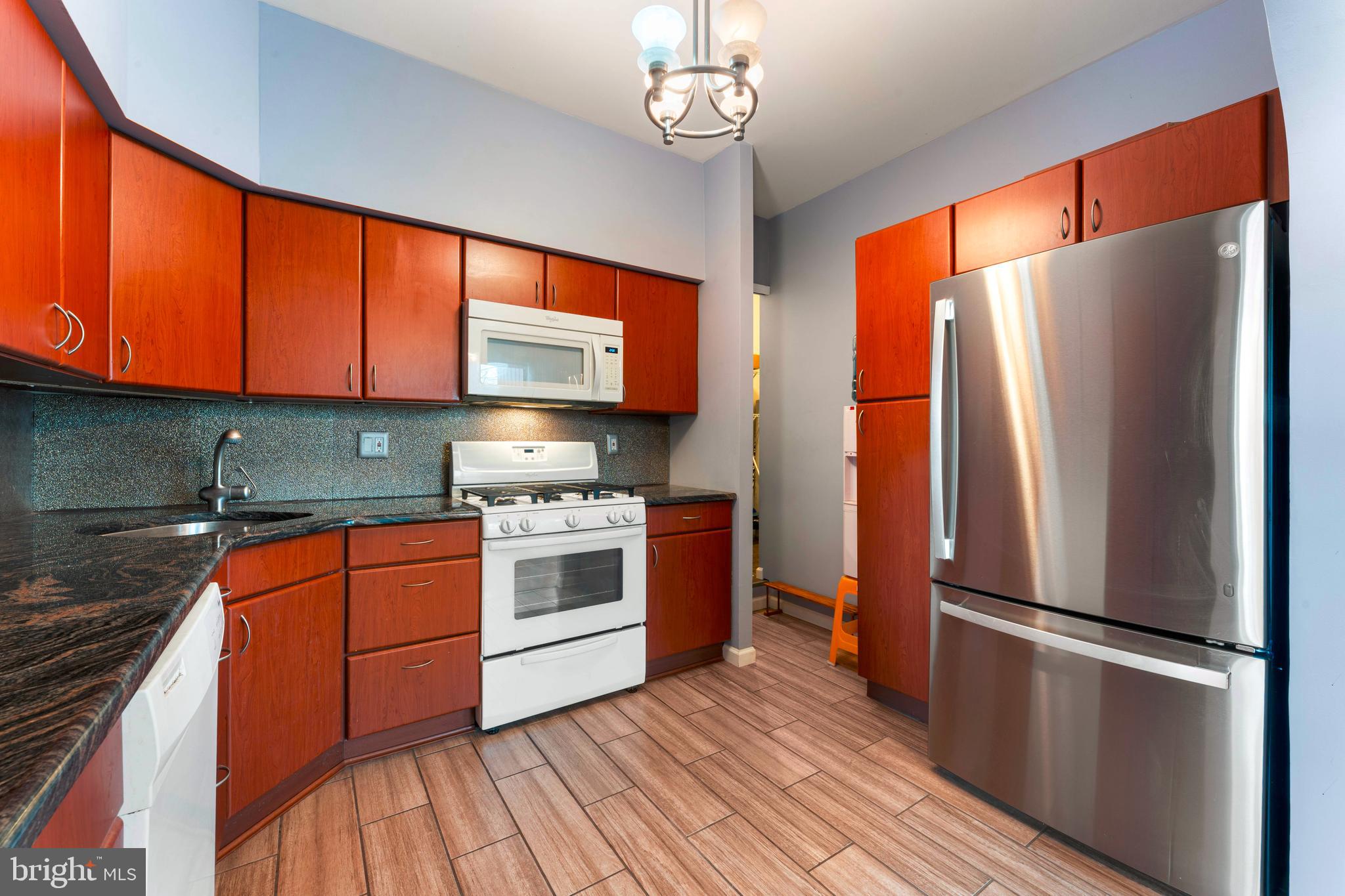 301 Byberry Road, Unit F1 Philadelphia, PA 19116 - Photo 13 of 30 a kitchen with stainless steel appliances granite countertop a refrigerator a sink dishwasher a stove and white countertops with wooden floor