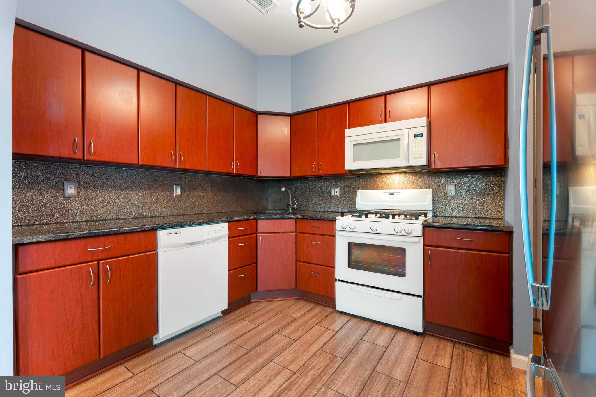 301 Byberry Road, Unit F1 Philadelphia, PA 19116 - Photo 14 of 30 a kitchen with stainless steel appliances granite countertop a stove a sink and a refrigerator