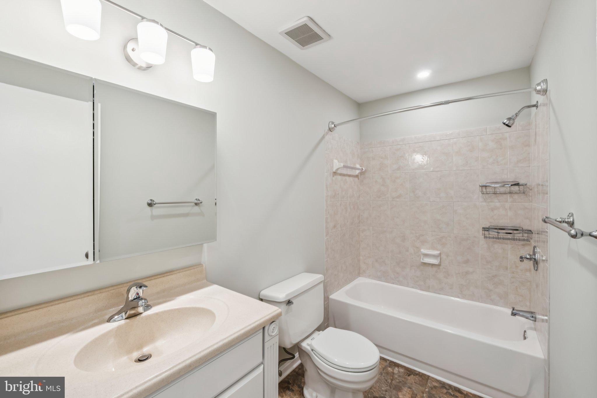 3437 Summit Court Northeast, Unit 3437 Washington, DC 20018 - Photo 11 of 26 a bathroom with a bathtub shower sink vanity mirror and toilet