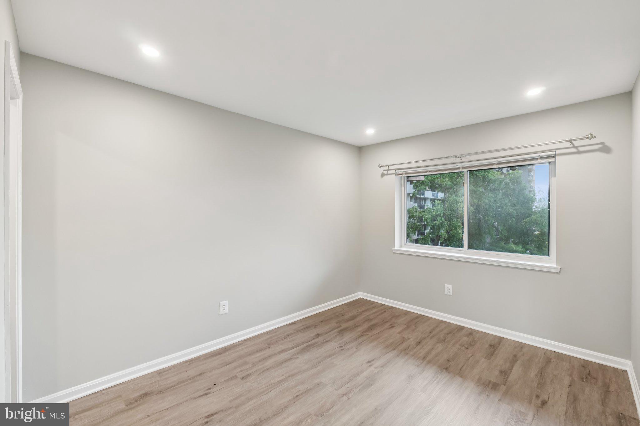 3437 Summit Court Northeast, Unit 3437 Washington, DC 20018 - Photo 13 of 26 an empty room with wooden floor and windows