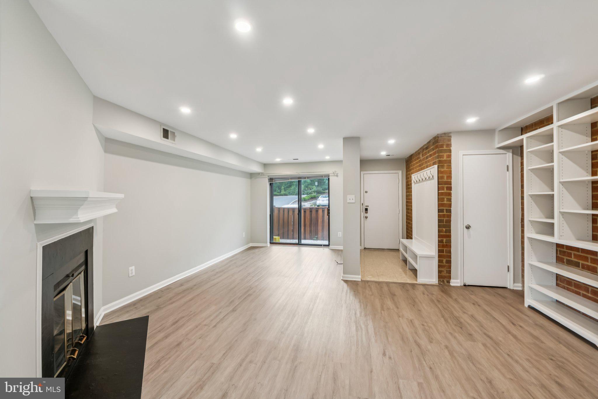 3437 Summit Court Northeast, Unit 3437 Washington, DC 20018 - Photo 4 of 26 a view of empty room with wooden floor and fireplace