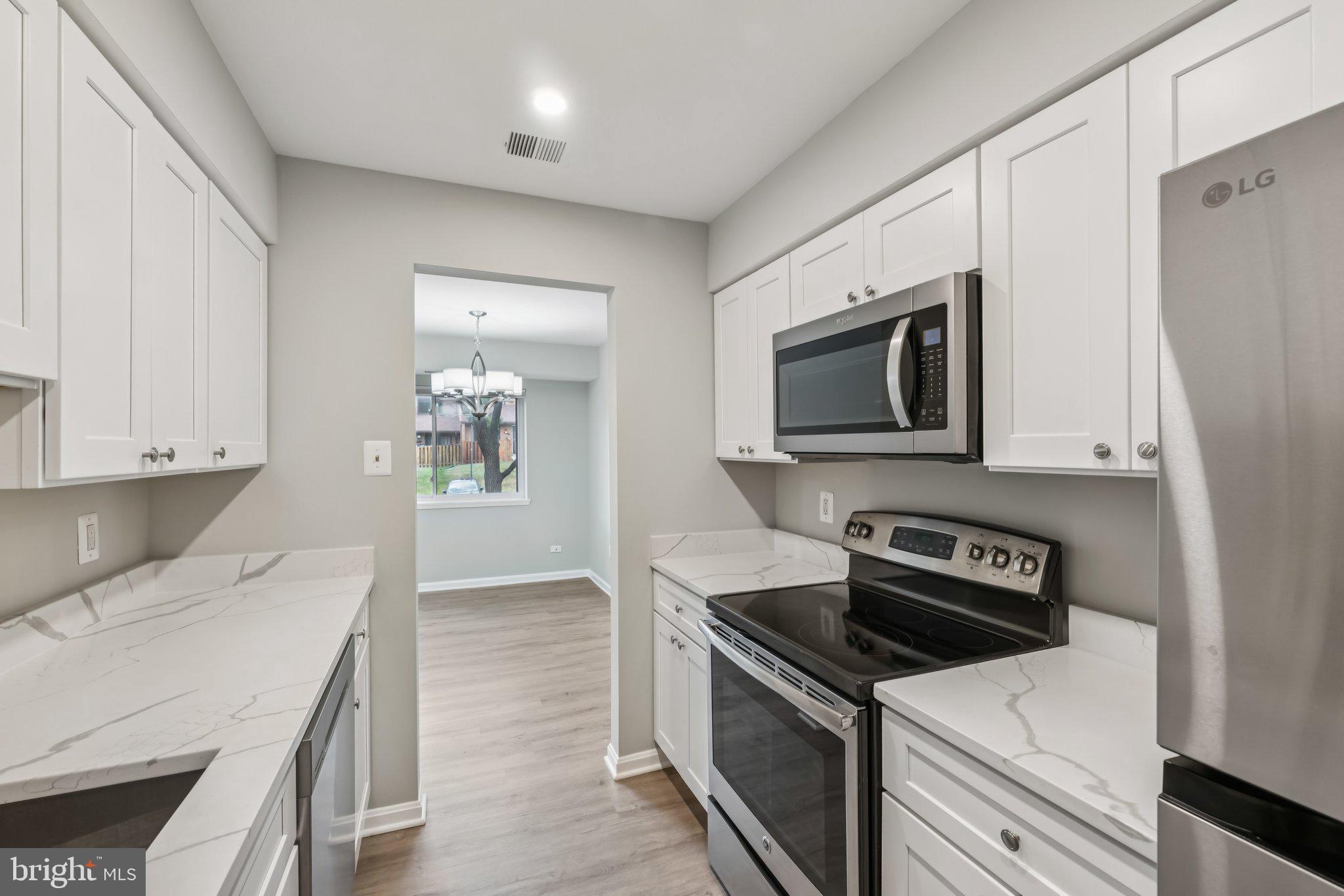 3437 Summit Court Northeast, Unit 3437 Washington, DC 20018 - Photo 9 of 26 a kitchen with stainless steel appliances a stove a microwave and cabinets