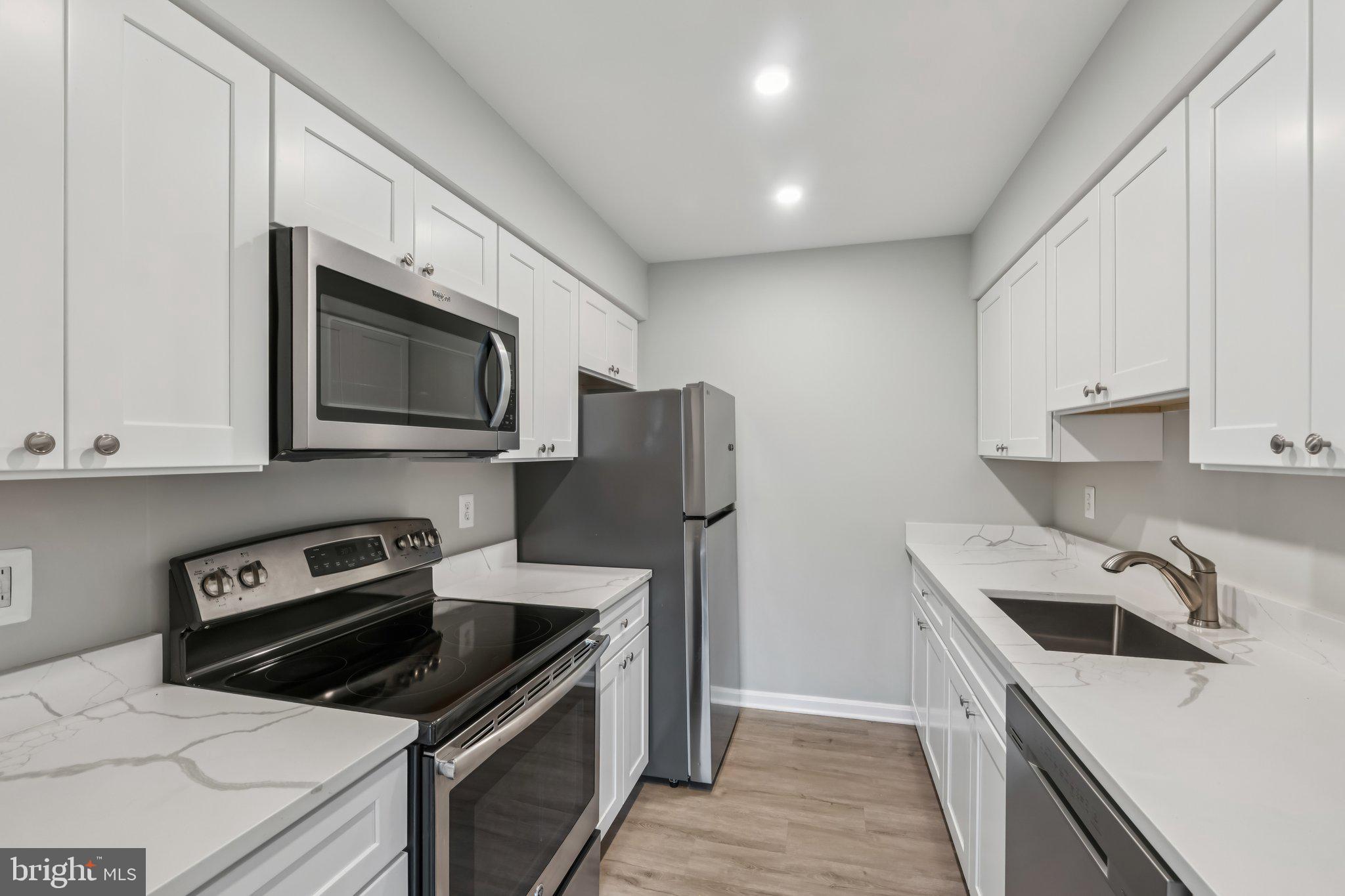 3437 Summit Court Northeast, Unit 3437 Washington, DC 20018 - Photo 10 of 26 a kitchen that has a sink and a stove top oven