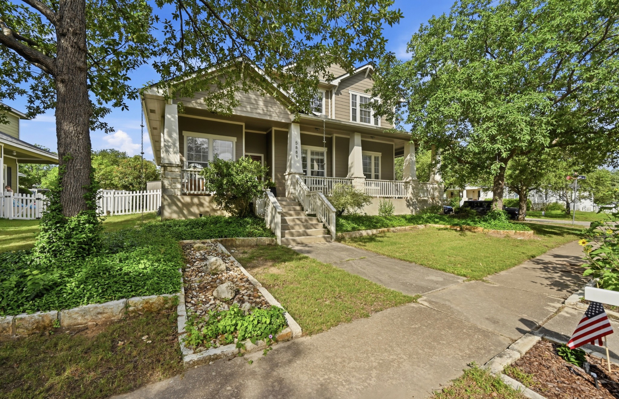 A classic facade with a welcoming porch and mature shade trees frames this charming home.
