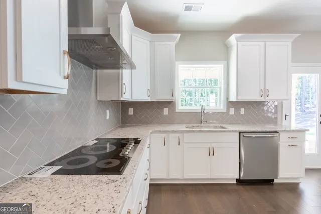 a kitchen with granite countertop a sink stove and cabinets