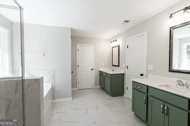 a bathroom with a double vanity sink mirror and shower