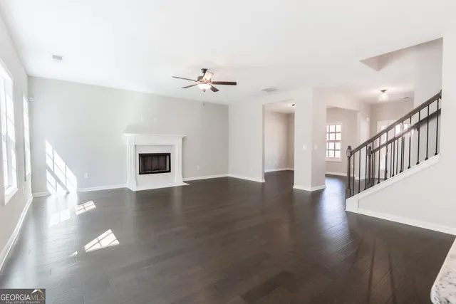 a view of a livingroom with wooden floor and a fireplace