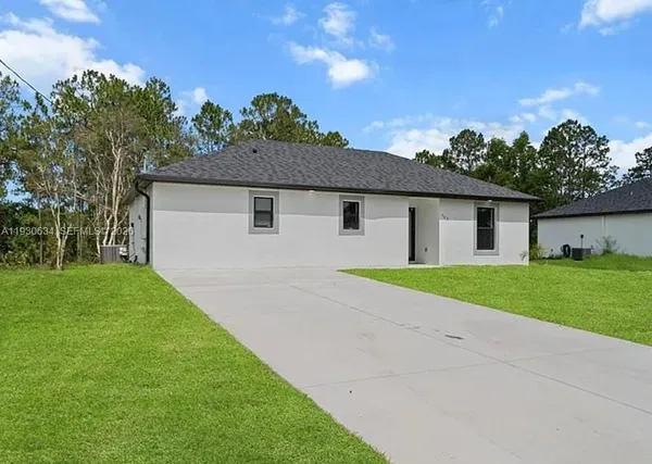 a front view of house with a garden