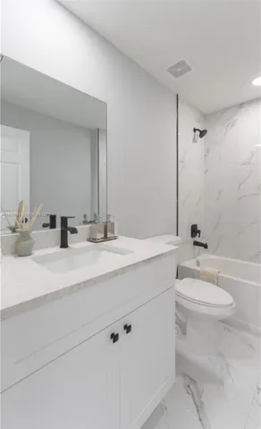 a bathroom with a double vanity sink toilet and a mirror