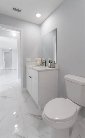a bathroom with a toilet a sink and mirror
