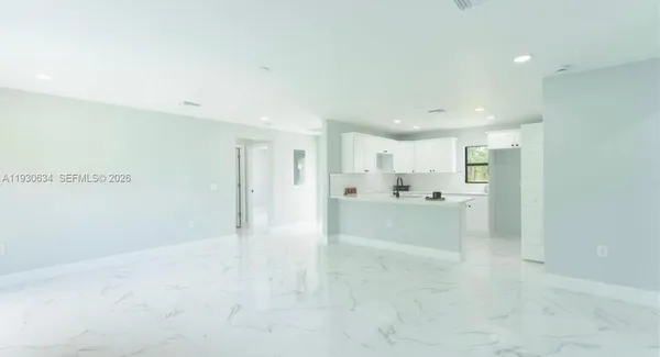 a view of a kitchen and a refrigerator a sink