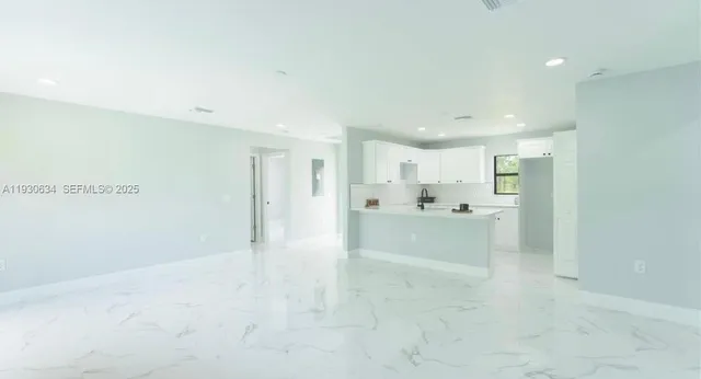 a view of a kitchen and a refrigerator a sink