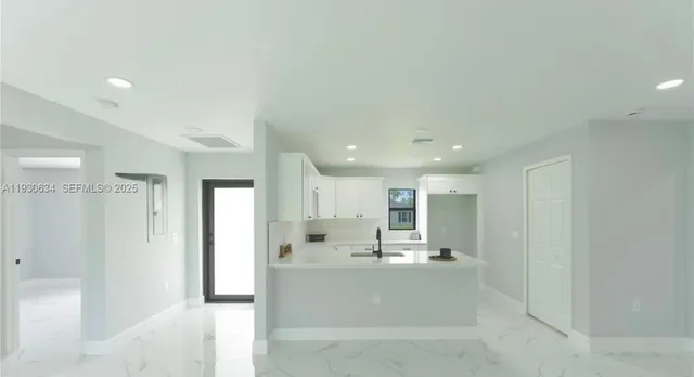 a view of kitchen with stainless steel appliances refrigerator sink and cabinets
