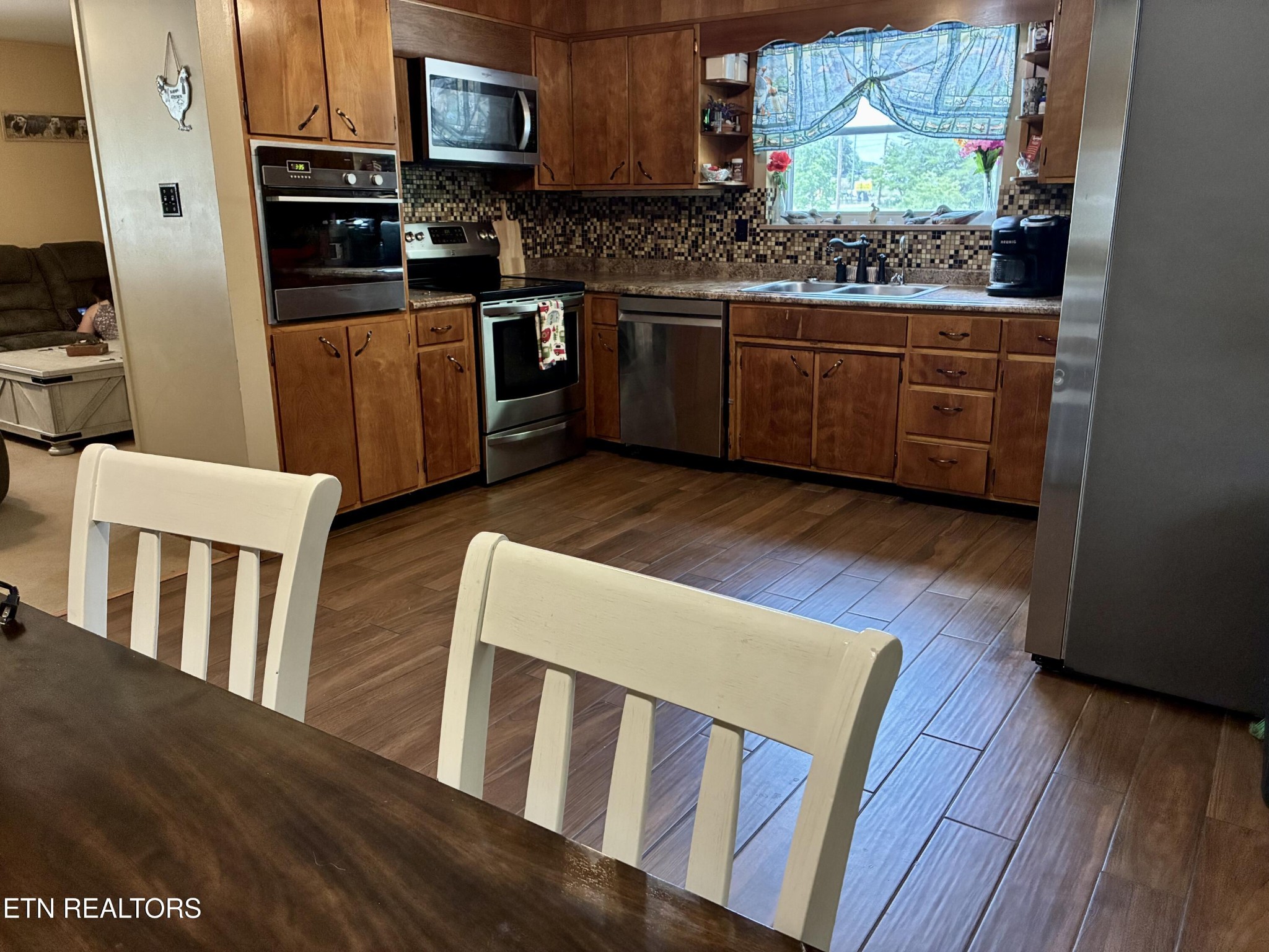1907 Tazewell Pike Corryton, TN 37721 - Photo 17 of 42 a kitchen with stainless steel appliances granite countertop wooden floors a stove and a microwave
