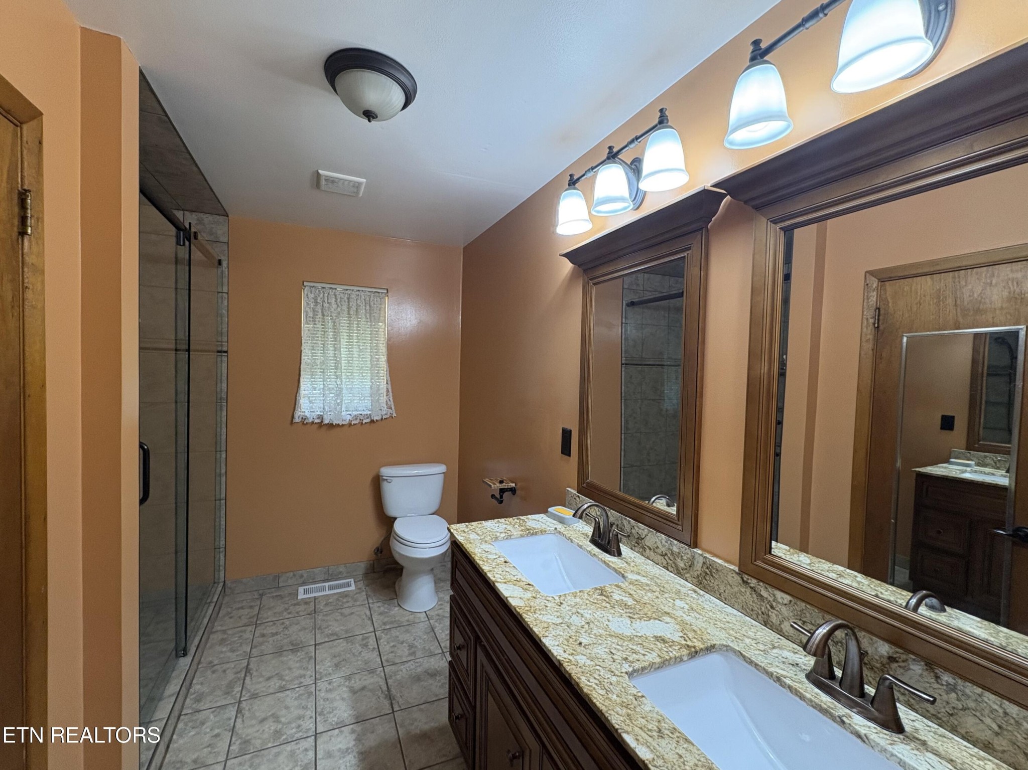1907 Tazewell Pike Corryton, TN 37721 - Photo 22 of 42 a bathroom with a granite countertop sink a toilet and mirror