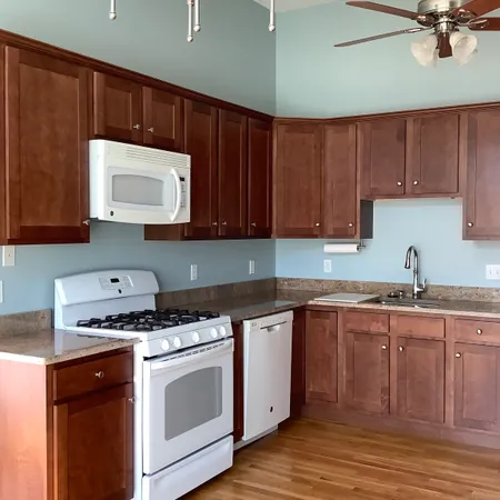 a kitchen with stainless steel appliances granite countertop a stove a sink and a microwave