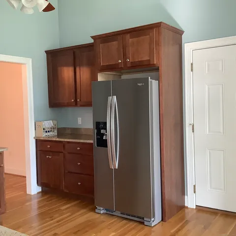 a kitchen with stainless steel appliances granite countertop a refrigerator and a cabinets