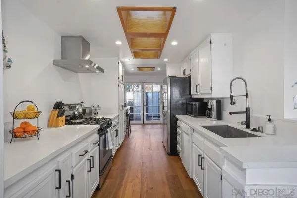 a kitchen with sink a stove and cabinets