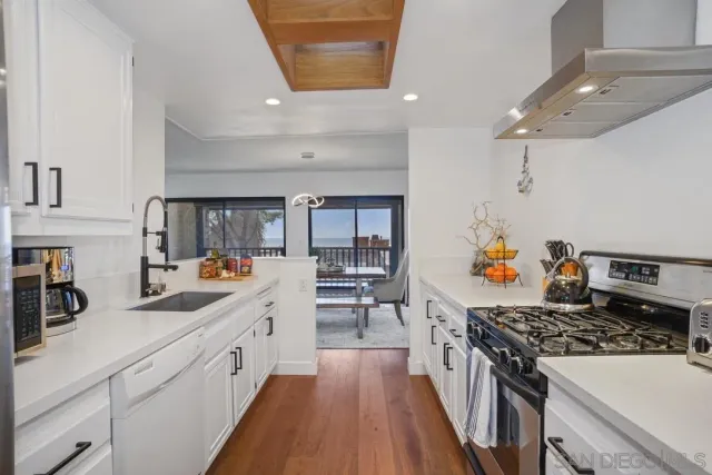 a kitchen with stove and wooden floor