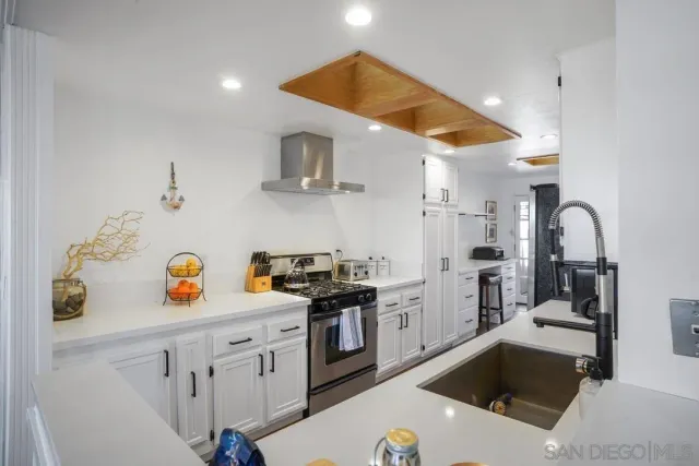 a kitchen with a sink a stove and cabinets