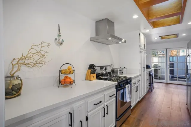 a kitchen with stainless steel appliances a sink a stove and wooden floor