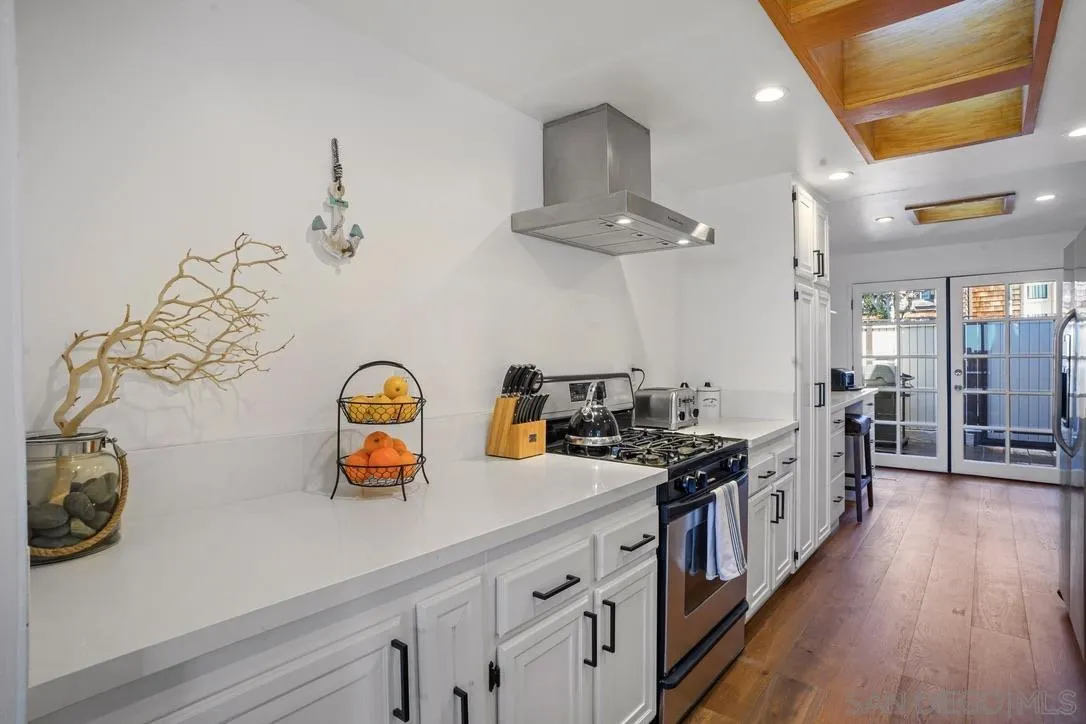 13053 Caminito Del Rocio Del Mar, CA 92014 - Photo 15 of 49 a kitchen with stainless steel appliances a sink a stove and wooden floor