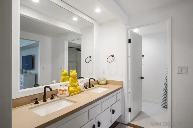 a bathroom with double vanity sinks and a mirror